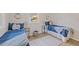 Guest bedroom with twin beds, blue bedding, and wood-look flooring at 5369 Tuscawilla Dr, Weeki Wachee, FL 34607
