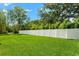 Green grassy backyard with a white vinyl fence at 5341 Lake Pearl Ct, Tampa, FL 33625