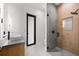 Modern bathroom with a glass shower, wood-like tile, and floating vanity at 5341 Lake Pearl Ct, Tampa, FL 33625
