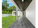 Long covered patio with dark stained ceiling, tile flooring and ceiling fans at 5341 Lake Pearl Ct, Tampa, FL 33625