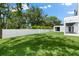 Large backyard, grassy lawn, and a white fence at 5341 Lake Pearl Ct, Tampa, FL 33625