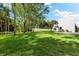Large backyard with lush lawn, mature trees, and white fence at 5341 Lake Pearl Ct, Tampa, FL 33625