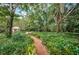 Brick pathway meandering through a vibrant garden at 2271 Keystone Rd, Tarpon Springs, FL 34688