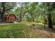 Landscaped backyard with red barn and shed at 2271 Keystone Rd, Tarpon Springs, FL 34688