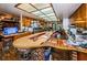 Long kitchen with an island, ample cabinetry, and brick flooring at 2271 Keystone Rd, Tarpon Springs, FL 34688