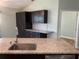 Modern kitchen with dark cabinets, granite counters and stainless steel appliances at 4115 Murfield E Dr, Bradenton, FL 34203