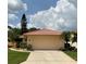 Tan house with tile roof, single car garage, and manicured lawn at 4115 Murfield E Dr, Bradenton, FL 34203