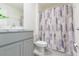 Clean bathroom with gray vanity, shower, and patterned curtain at 810 Ace Outlaw Ave, Ruskin, FL 33570