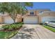 Tan townhome exterior with two-car garage and landscaping at 184 Valencia Cir, St Petersburg, FL 33716