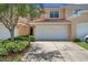 Two-story tan townhouse with attached garage and landscaping at 184 Valencia Cir, St Petersburg, FL 33716