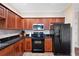 Modern kitchen with dark wood cabinets and black appliances at 184 Valencia Cir, St Petersburg, FL 33716