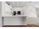 Kitchen features a breakfast bar, white cabinets and dark appliances at 31421 Anniston Dr, Wesley Chapel, FL 33543