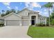 Two-story house with three-car garage and landscaping at 31421 Anniston Dr, Wesley Chapel, FL 33543