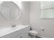Clean bathroom with white vanity, toilet and decorative mirror at 31421 Anniston Dr, Wesley Chapel, FL 33543