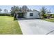 Single-wide mobile home with carport and clover driveway at 37700 Neukom Ave, Zephyrhills, FL 33541