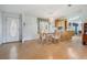 Open dining room with glass table and view into the kitchen at 37700 Neukom Ave, Zephyrhills, FL 33541