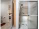 Bathroom featuring a walk-in shower with grab bars and glass enclosure at 37700 Neukom Ave, Zephyrhills, FL 33541