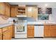 Bright kitchen with light wood cabinets, white appliances, and light blue countertops at 37700 Neukom Ave, Zephyrhills, FL 33541