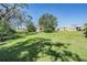 Large grassy backyard with mature trees and two homes visible at 37700 Neukom Ave, Zephyrhills, FL 33541