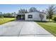 Front view of a single-wide manufactured home with carport at 37700 Neukom Ave, Zephyrhills, FL 33541