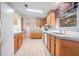 Open kitchen with light wood cabinets, white appliances, and vinyl flooring at 37700 Neukom Ave, Zephyrhills, FL 33541