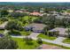 Landscaped property with a large home, three-car garage, and mature trees at 13216 Legends Trl, Dade City, FL 33525