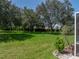 A beautiful, well-maintained backyard with expansive lawn, mature trees, and meticulous landscaping at 13216 Legends Trl, Dade City, FL 33525