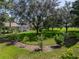 A lush backyard featuring mature trees, verdant grass, and immaculate landscaping at 13216 Legends Trl, Dade City, FL 33525