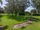 A lush backyard featuring mature trees, verdant grass, and meticulous landscaping at 13216 Legends Trl, Dade City, FL 33525