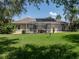 Spacious backyard featuring a screened-in patio and well-maintained lawn at 13216 Legends Trl, Dade City, FL 33525