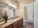Bathroom with granite countertops, modern fixtures, and a tiled walk-in shower at 13216 Legends Trl, Dade City, FL 33525