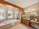 A stunning bathroom features a soaking tub, a large vanity area and travertine floors at 13216 Legends Trl, Dade City, FL 33525