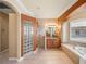 Large bathroom with glass block shower, soaking tub, and granite counters on the vanity at 13216 Legends Trl, Dade City, FL 33525