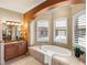 A spacious bathroom boasts a soaking tub, granite counters and a large vanity area at 13216 Legends Trl, Dade City, FL 33525