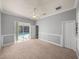 Bedroom with gray walls, a ceiling fan, carpet floors and access to the screened-in pool area at 13216 Legends Trl, Dade City, FL 33525