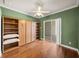 Bedroom with hardwood floors and built-in murphy bed and shelves at 13216 Legends Trl, Dade City, FL 33525