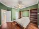 Bedroom featuring built in bookcases, hardwood floors and a ceiling fan at 13216 Legends Trl, Dade City, FL 33525
