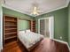 Bedroom with hardwood floors, built-in shelves, and sliding glass doors to the backyard at 13216 Legends Trl, Dade City, FL 33525