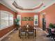 Warm dining room with tray ceiling, wood floors, and plantation shutters at 13216 Legends Trl, Dade City, FL 33525