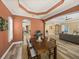 Elegant dining room with dark wood table and decorative tray ceiling open to the living areas at 13216 Legends Trl, Dade City, FL 33525