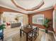 Elegant dining room with a dark wood table, designer ceiling and views into the home's other living areas at 13216 Legends Trl, Dade City, FL 33525