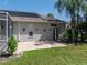 Exterior view of the home featuring solar panels, a brick patio and backyard garden at 13216 Legends Trl, Dade City, FL 33525