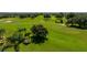 Lush golf course view with manicured green fairways, trees and sand traps on a sunny day at 13216 Legends Trl, Dade City, FL 33525