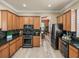 Well-appointed kitchen featuring wood cabinets, black appliances, and granite countertops at 13216 Legends Trl, Dade City, FL 33525