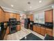 Well-appointed kitchen featuring wood cabinets, black appliances, and granite countertops at 13216 Legends Trl, Dade City, FL 33525