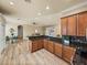 Open kitchen with wood cabinets and granite countertops overlooks the dining and living areas at 13216 Legends Trl, Dade City, FL 33525