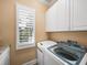 Laundry Room with white cabinets, shutters and a washer and dryer at 13216 Legends Trl, Dade City, FL 33525