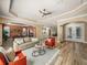 Expansive living room with wood floors and access to the dining room and kitchen at 13216 Legends Trl, Dade City, FL 33525