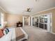 Expansive main bedroom features a ceiling fan, fireplace, and sliding glass doors to the patio at 13216 Legends Trl, Dade City, FL 33525