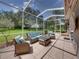 Comfortable screened patio with wicker furniture, ideal for enjoying the outdoors at 13216 Legends Trl, Dade City, FL 33525